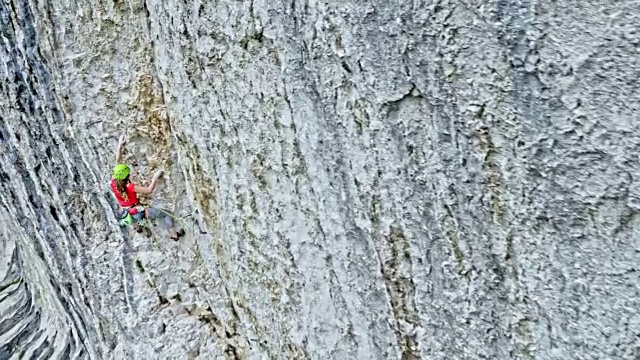 女攀登者站在悬崖边，拉着绳子穿过快扣视频素材