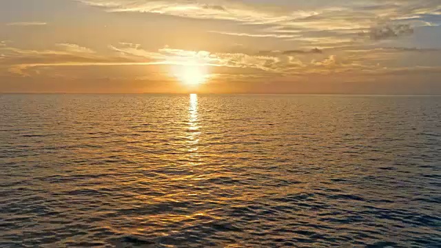 当太阳落山时，空中的人在海上划桨视频素材