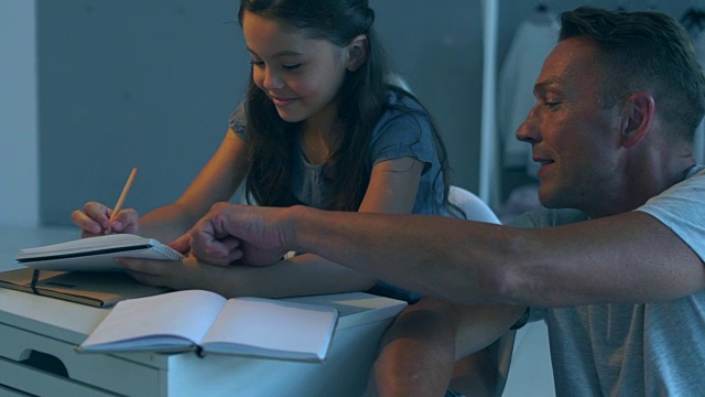 积极的父亲帮助他的小女儿完成家庭作业视频购买