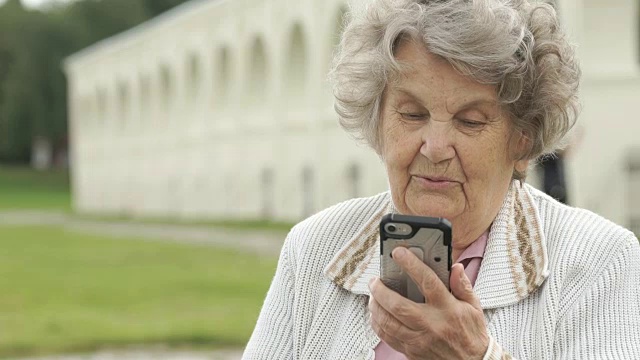一位老妇人在用智能手机和朋友聊天视频素材