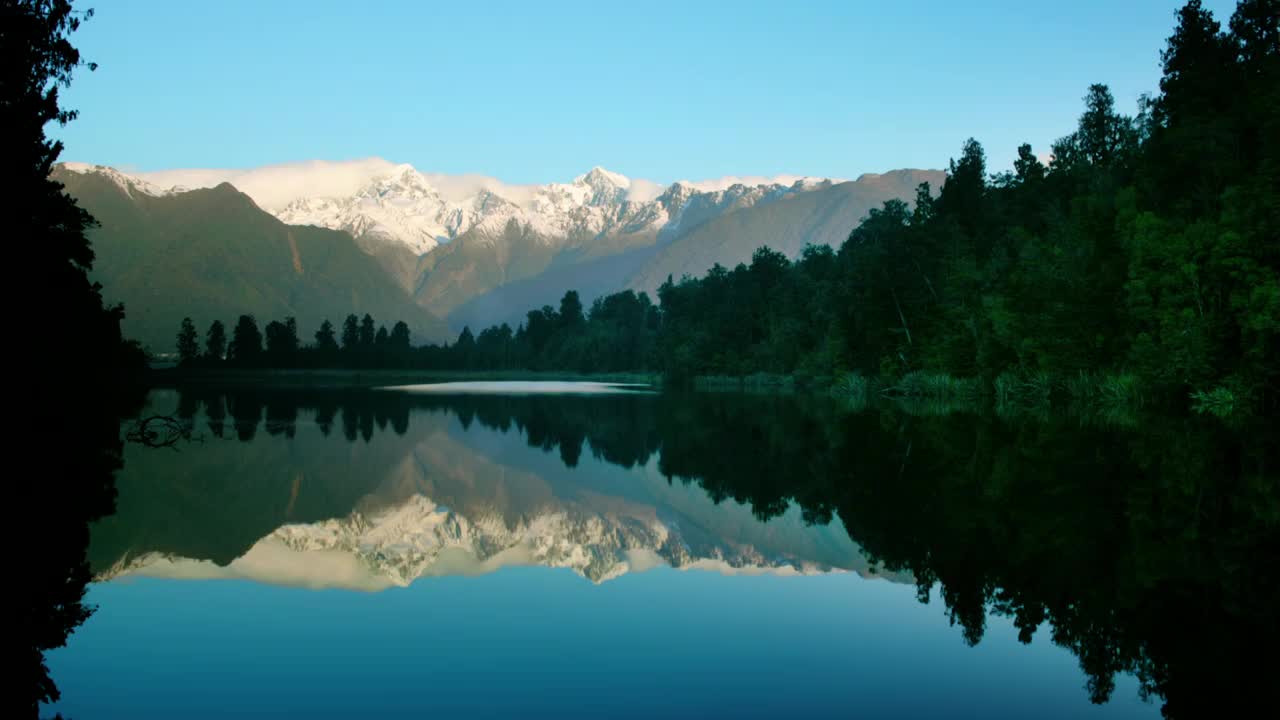 时间推移广泛拍摄的太阳在库克山和塔斯曼山反映在马西森湖/南岛，新西兰视频素材