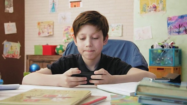 可爱的小男孩在玩手机游戏视频素材