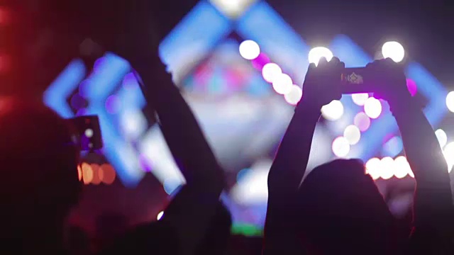 人群在音乐会上举起双手剪影，为音乐节欢呼的人群视频下载
