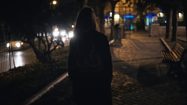 后视镜的女游客背包走在黑暗的公园附近的路深夜独自视频下载