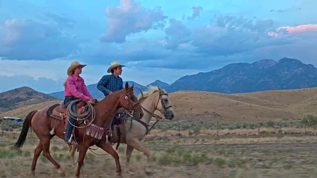 两个朋友骑马在犹他州黄昏的实时视频。视频素材
