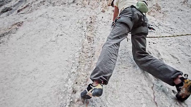 下面是一名男性攀岩者正在攀登一处垂直的白色悬崖视频下载