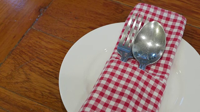 餐厅里白色盘子上的一套勺子和叉子视频素材
