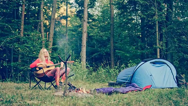 露营。弹奏吉他的女人视频素材
