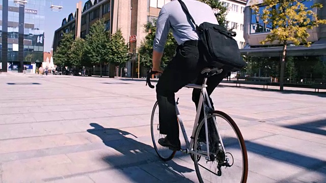 SLO MO一个不知名的商人骑着他的自行车视频素材