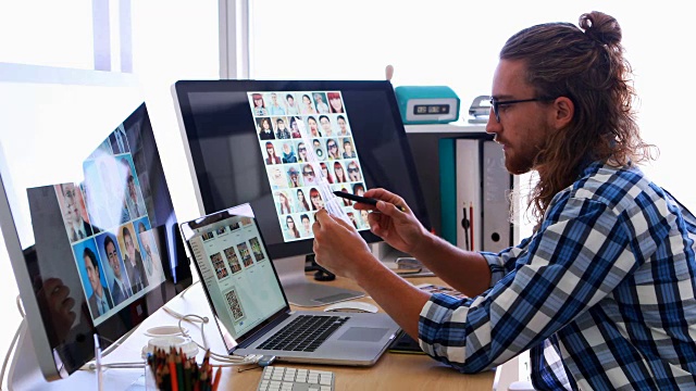一名男性高管在办公桌前使用笔记本电脑和图形平板电脑，工作时间是4k视频下载