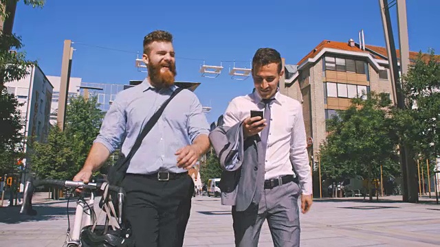 两个商人在城市里用手机看东西视频素材