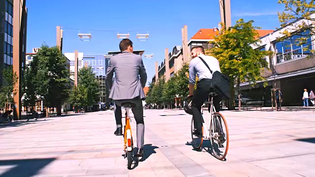 SLO MO两个同事在城市里骑自行车视频素材
