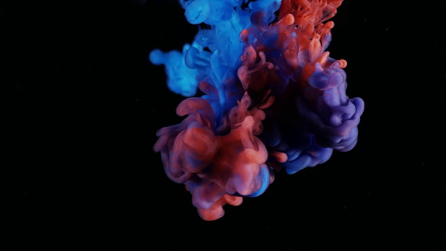 红色和蓝色墨水滴在水中黑色背景视频素材