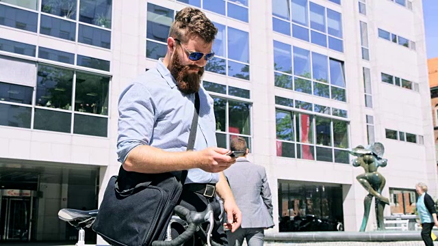 DS潮人戴着太阳镜在城市里使用智能手机视频素材