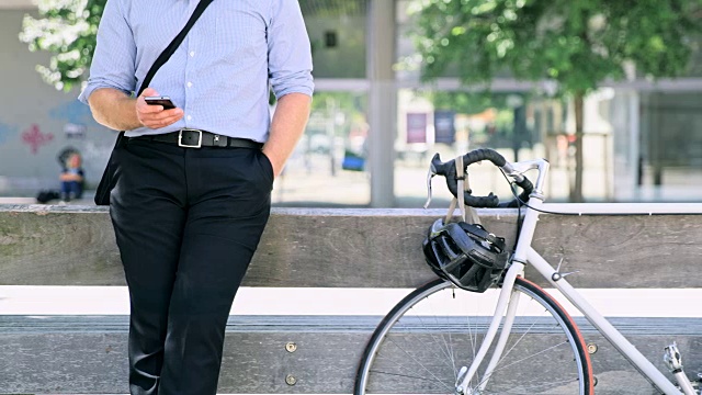 一个穿衬衫的男人在城市里使用智能手机视频素材