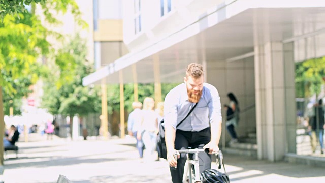 DS潮人在城市里骑自行车时查看他的智能手机视频素材