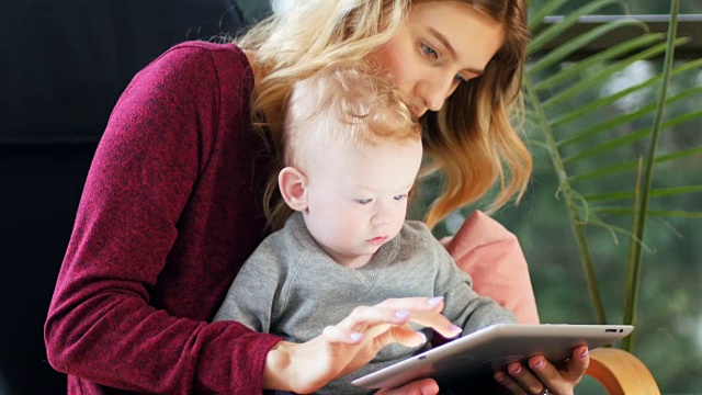 母亲和婴儿在家里使用数码平板电脑4k视频素材
