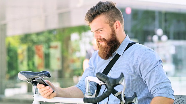 蓄着胡子的男子在办公大楼前使用智能手机视频素材