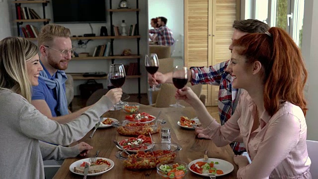 一群快乐的朋友在餐厅用餐，用红酒敬酒。视频素材