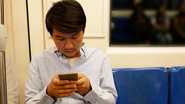 亚洲男人在火车上使用手机视频素材