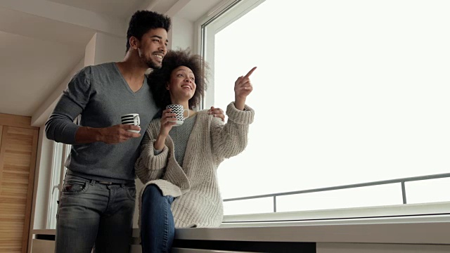 幸福的黑人夫妇享受着他们的咖啡时间在窗口和交流。视频素材