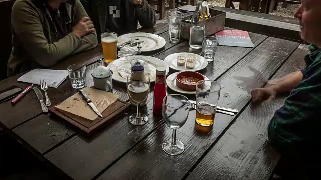一个布丁花园桌子的特写，朋友们享受一杯饮料和传统的周日烤肉视频下载