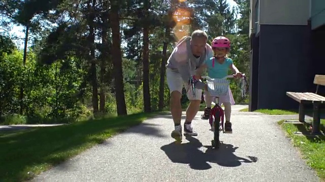 爸爸教女儿骑自行车视频素材