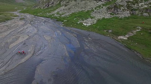 两个骑山地车的人在河床上被拍下来。视频素材