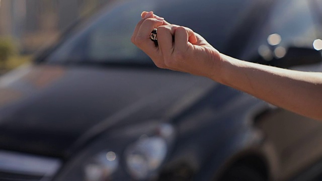 一个女人得到了一辆黑色汽车的新钥匙。视频素材