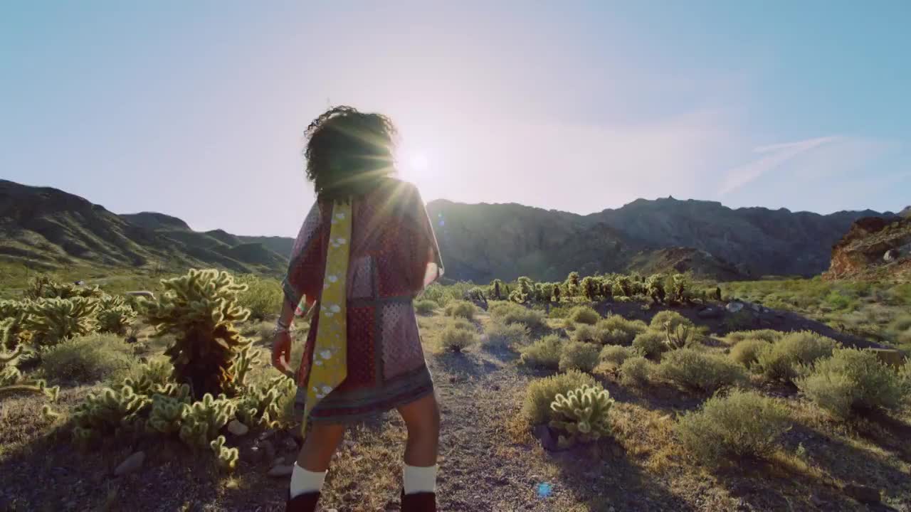 爱冒险的年轻女子在沙漠的阳光下笑着旋转。视频下载