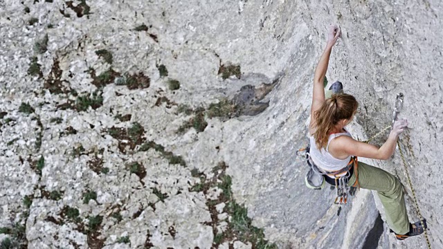 SLO MO女攀岩者在岩壁高处放手视频下载