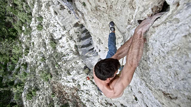 SLO MO男性攀登者在攀登时在悬崖中找到一个抓地力视频下载