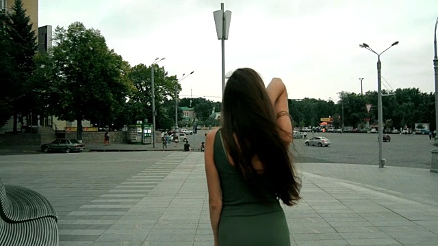 身材苗条的黑发少女背对着镜头站在街上视频素材