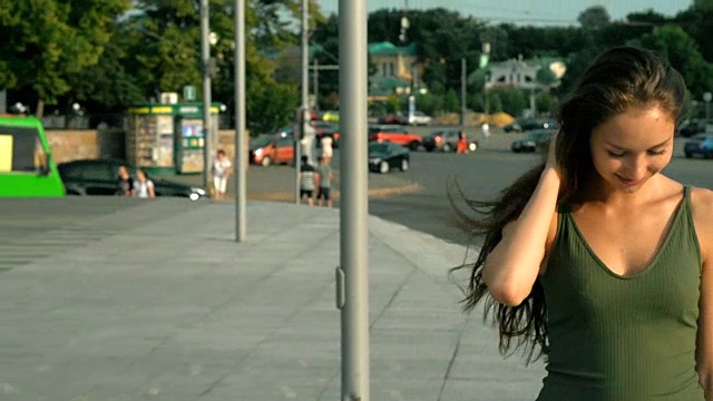 漂亮的微笑女孩走在街上看着镜头视频素材