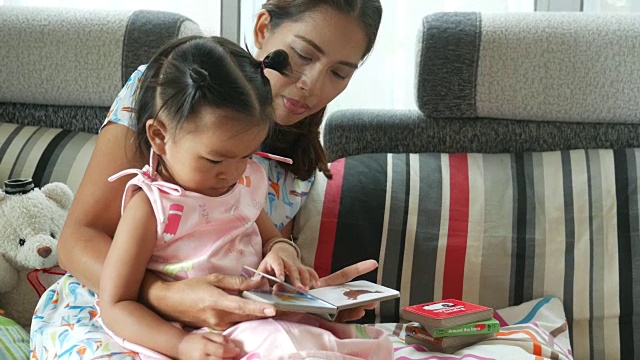 亚洲宝宝和妈妈一起玩和看书视频素材
