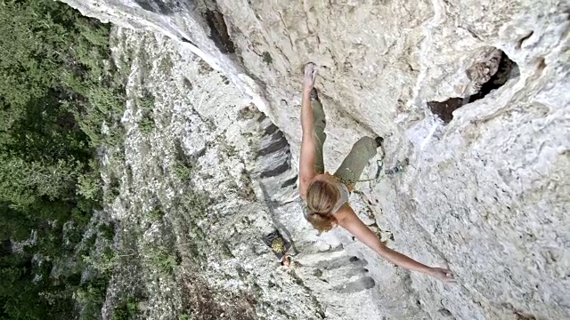 就在一位女性攀岩者正在攀登悬崖的上方视频素材