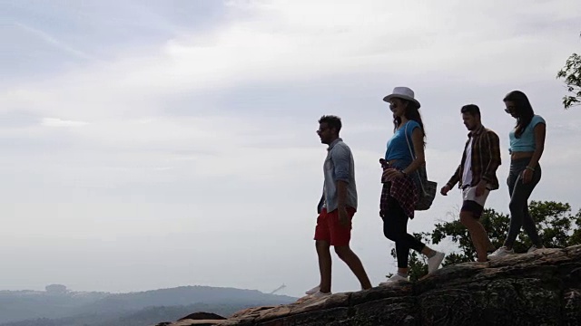 一群游客在山顶高举双手享受自由，快乐的男男女女在早晨看风景视频素材