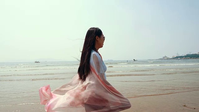戴着围巾在海边散步的女人视频下载