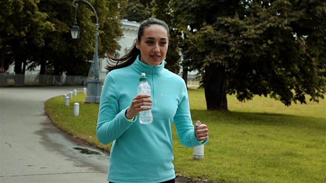 女性跑步者饮用水瓶视频素材