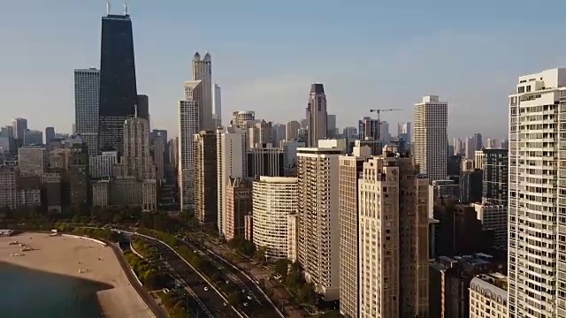 鸟瞰图美丽的芝加哥城市景观。无人机飞离摩天大楼和密歇根湖，加速。视频素材