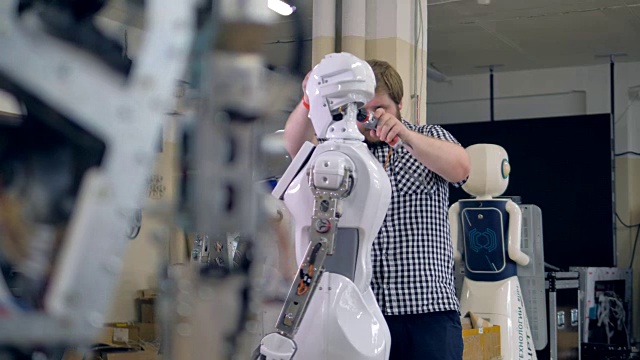 一个年轻的工程师拆开一个机器人的头。视频下载