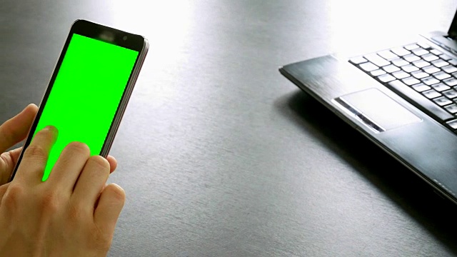 摄影:在办公桌上用绿色屏幕为色度键的手机拍摄视频素材