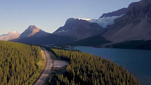 空中拍摄的湖和道路与背景山日落视频购买