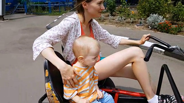 妈妈和儿子骑自行车享受游乐园视频下载