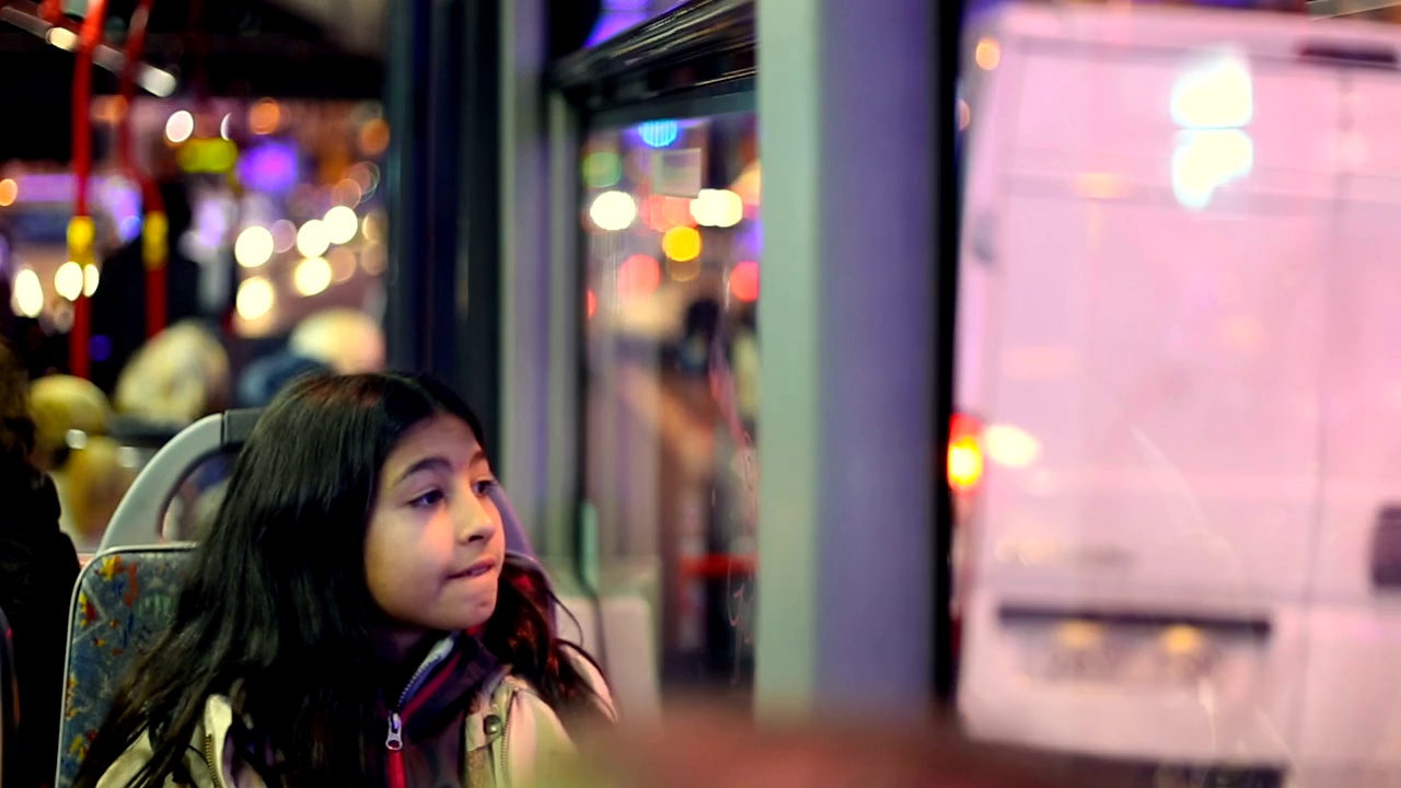 可爱的黑发女孩高兴与圣诞灯饰在城市。视频素材