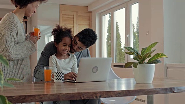 一个年轻的非裔美国家庭在家里一起使用笔记本电脑。视频素材