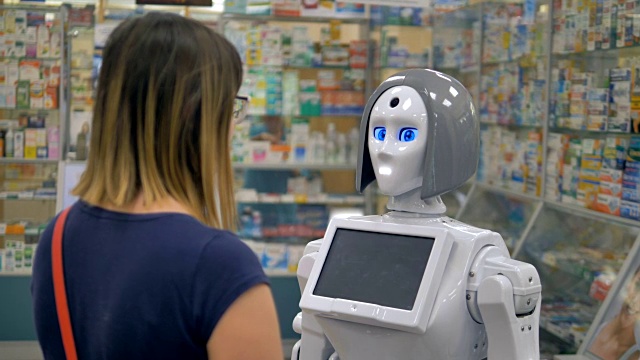一个人形机器人正在药店里咨询一位女士。视频素材