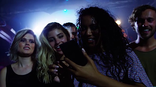 一群朋友在4k音乐会上用手机浏览照片视频素材