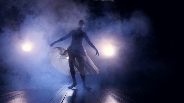 一位女舞者匆匆穿过黑暗的舞台。视频下载