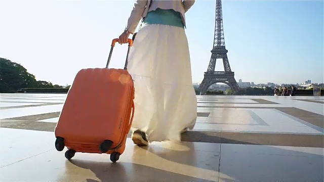 拿着橙色手提箱的女人去巴黎旅行视频素材